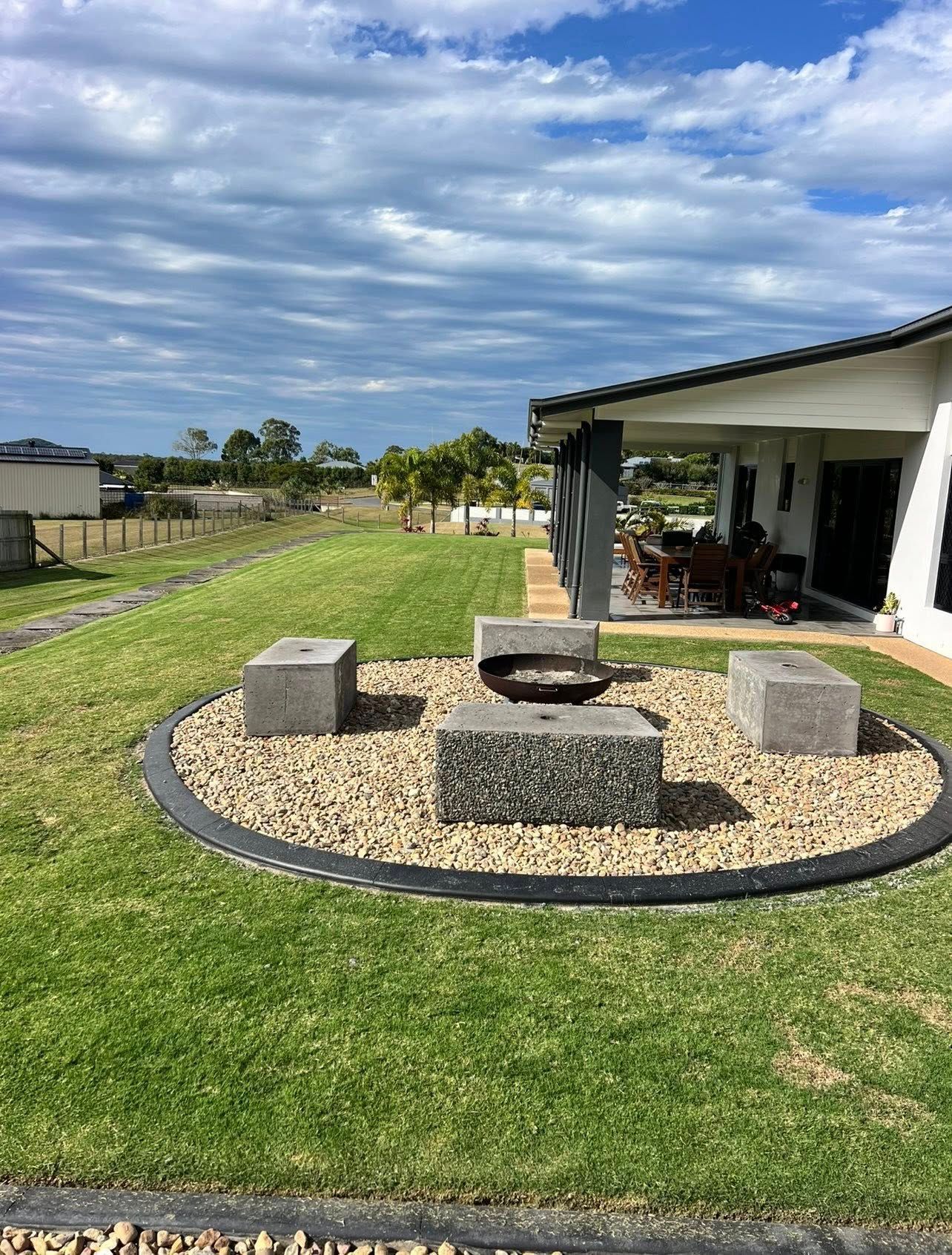 Backyard with A Gravel Fire Pit Area, Concrete Benches — Barlow's Earthmoving in Coorooman, QLD