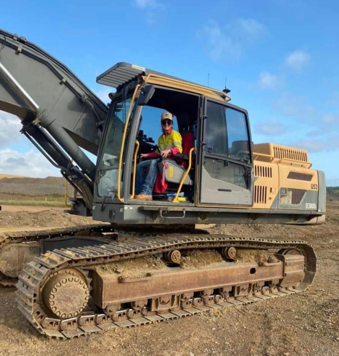 Excavator on a Dirt Site With a Worker in the Cab, Boom Raised Against a Blue Sky — Barlow's Earthmoving in Coorooman, QLD