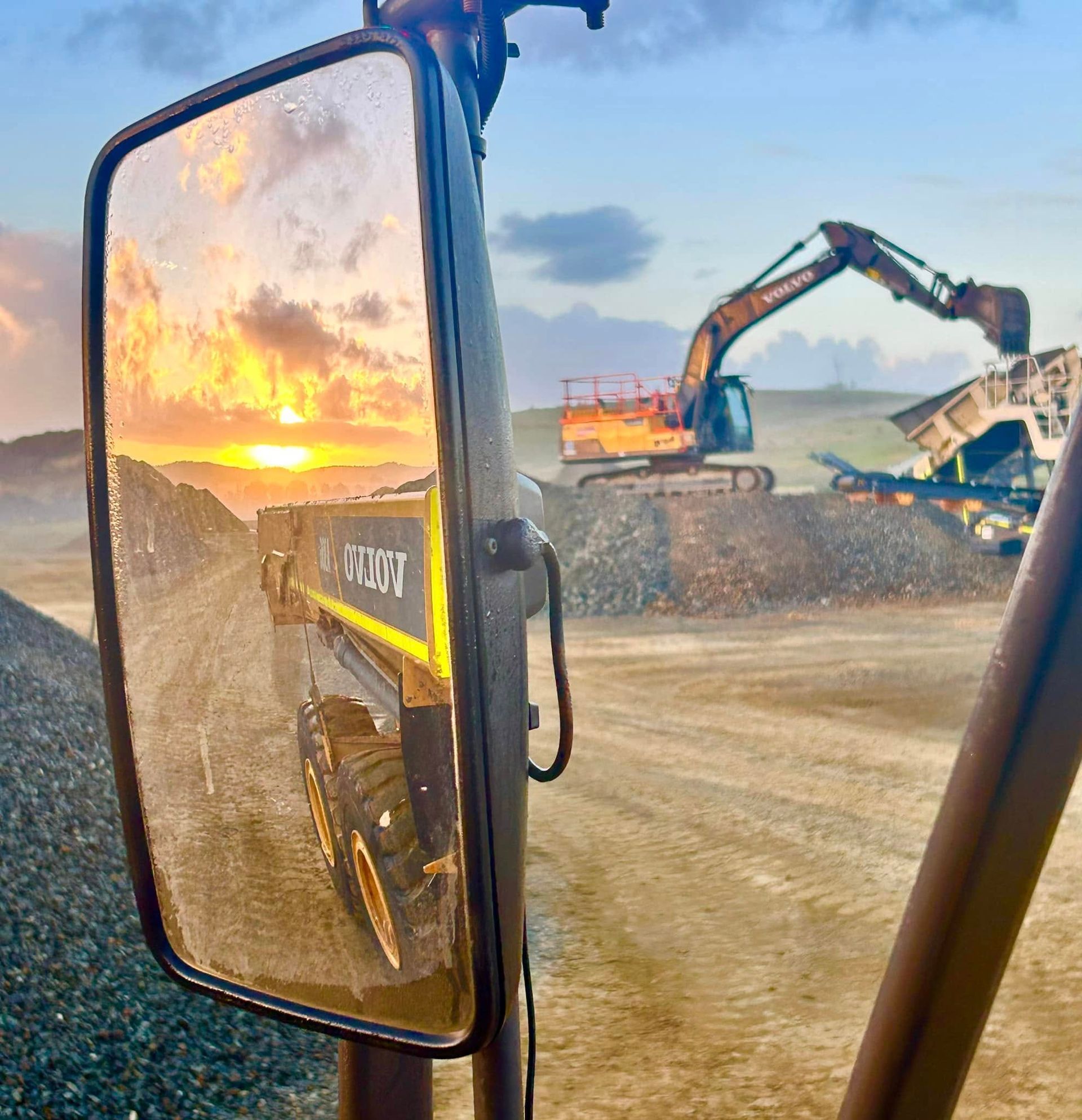 Construction Site at Sunrise, Seen Through a Truck Mirror With Excavator Working — Barlow's Earthmoving in Coorooman, QLD