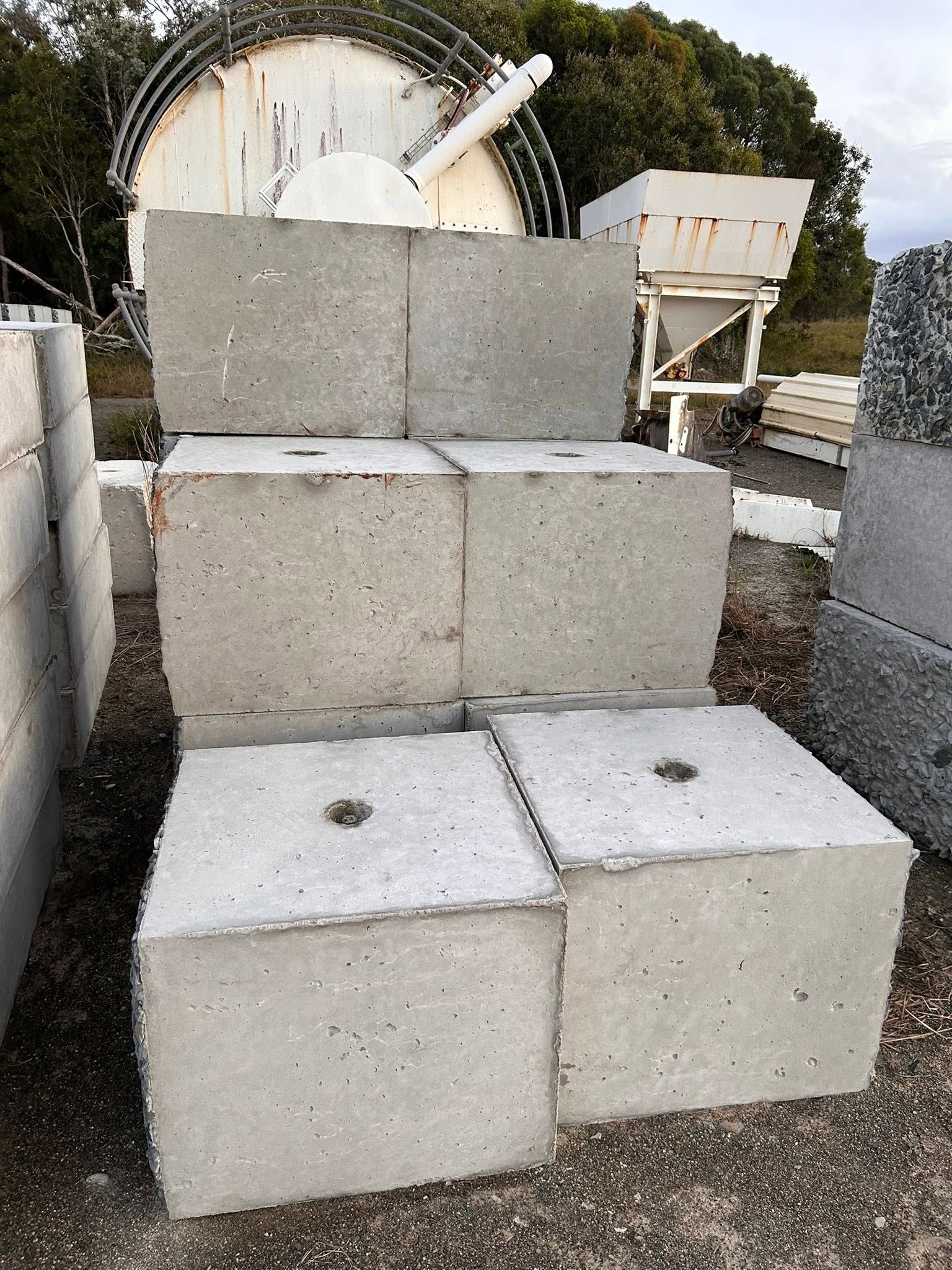 Stacked Concrete Blocks and Equipment Outdoors, With a Large Round Tank — Barlow's Earthmoving in Coorooman, QLD