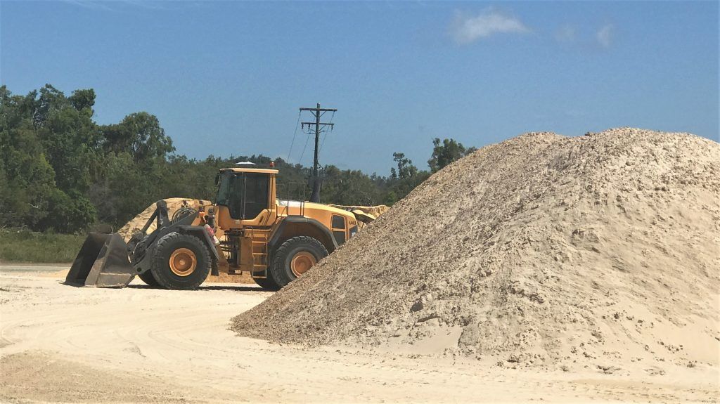 Yellow Loader Next to A Large Pile of Sand on A Construction Site — Barlow's Earthmoving in Coorooman, QLD