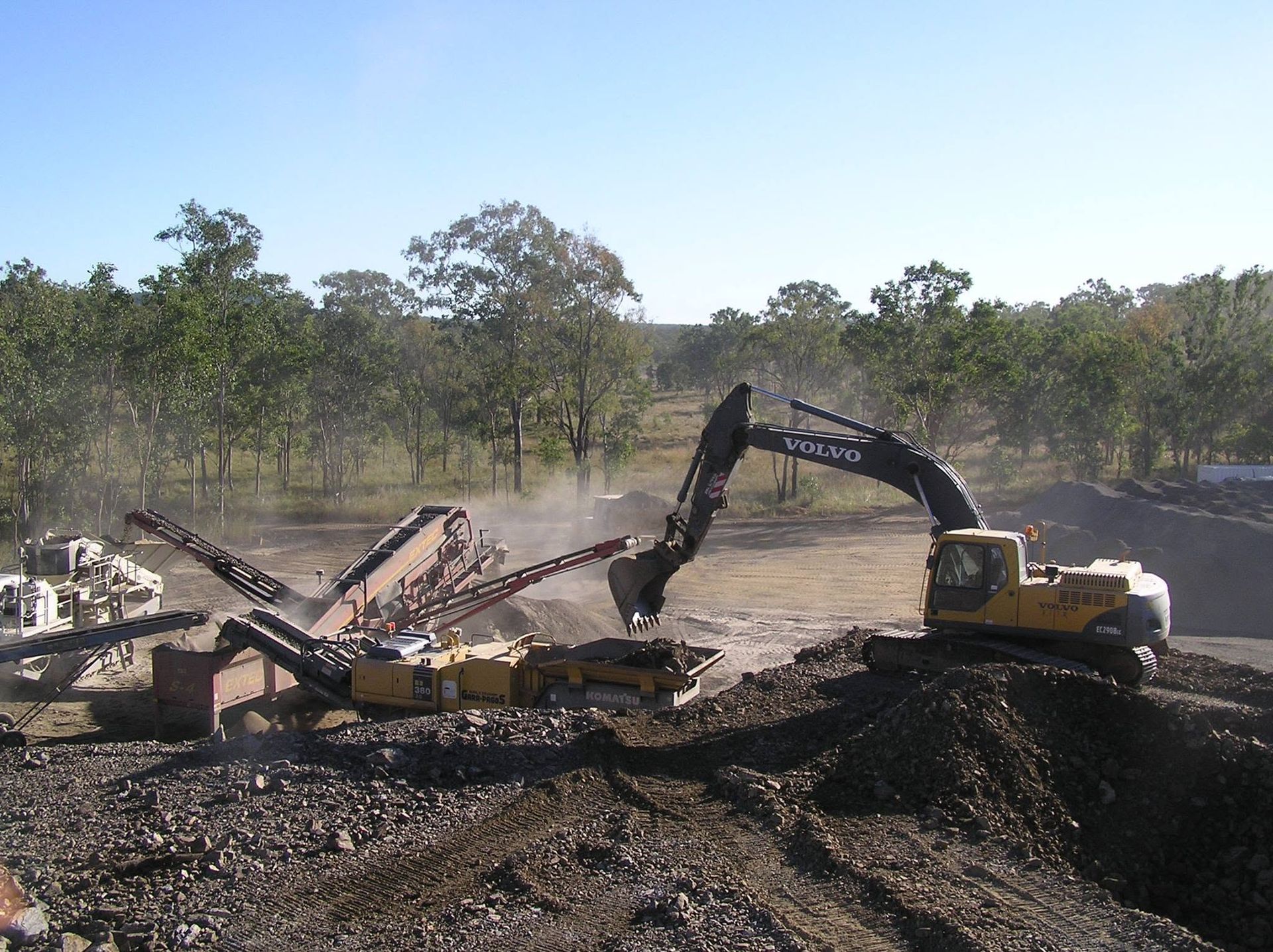 Excavator Dumping Soil Beside a Conveyor at a Dirt Quarry, With Trees — Barlow's Earthmoving in Coorooman, QLD