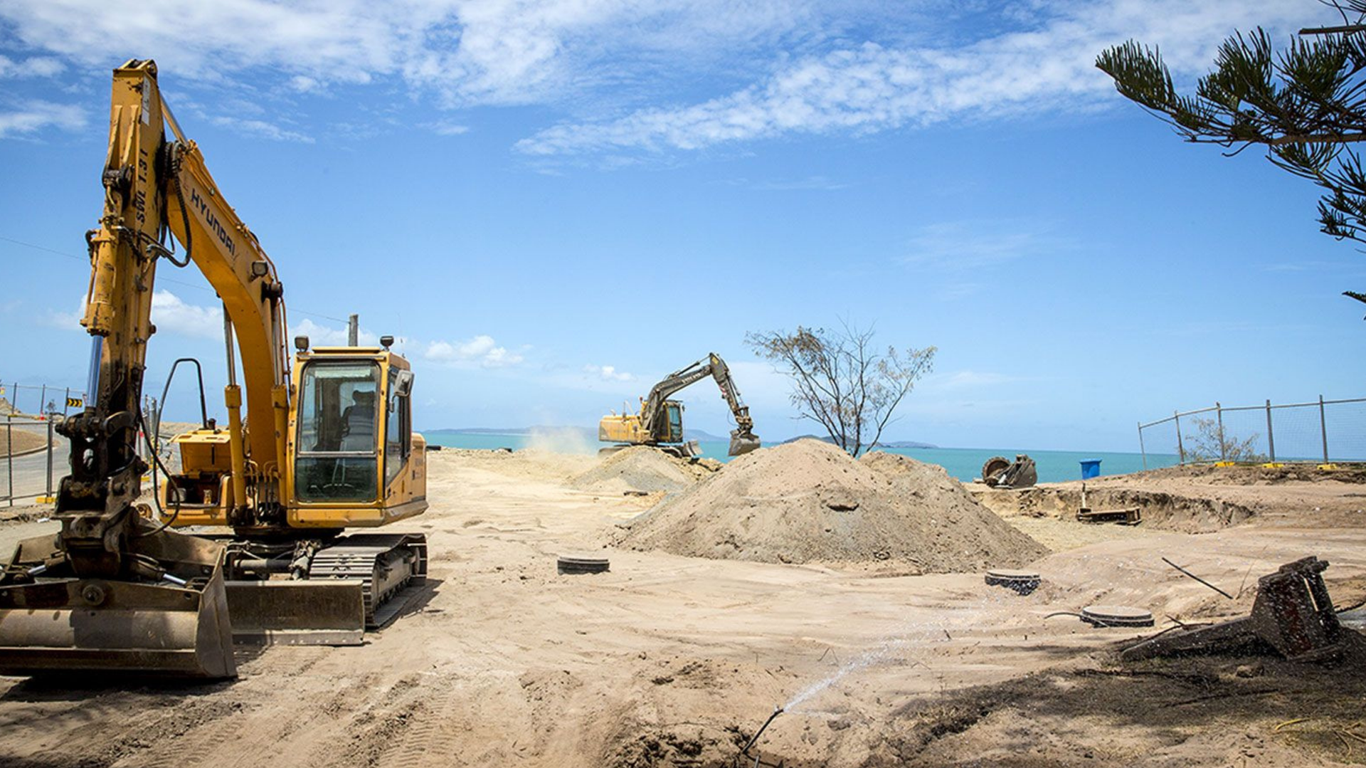 Yellow Excavators on A Construction Site Near the Ocean, with Sand and A Blue Sky — Barlow's Earthmoving in Coorooman, QLD