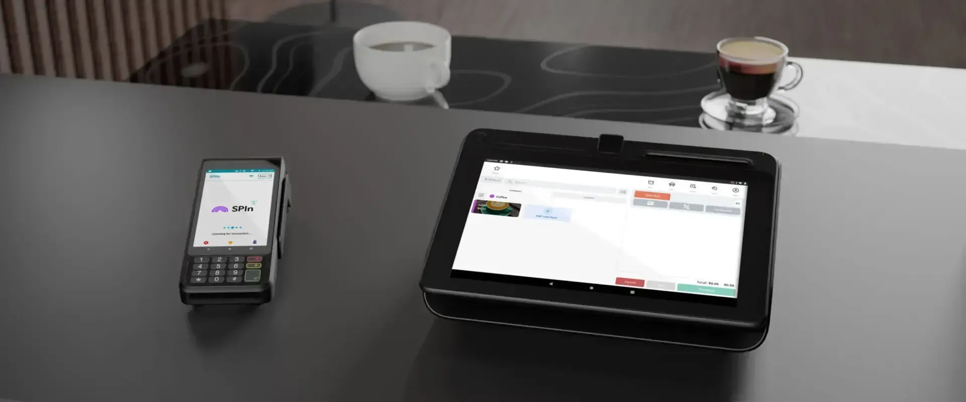 A tablet is sitting on a table next to a phone and a cup of coffee.