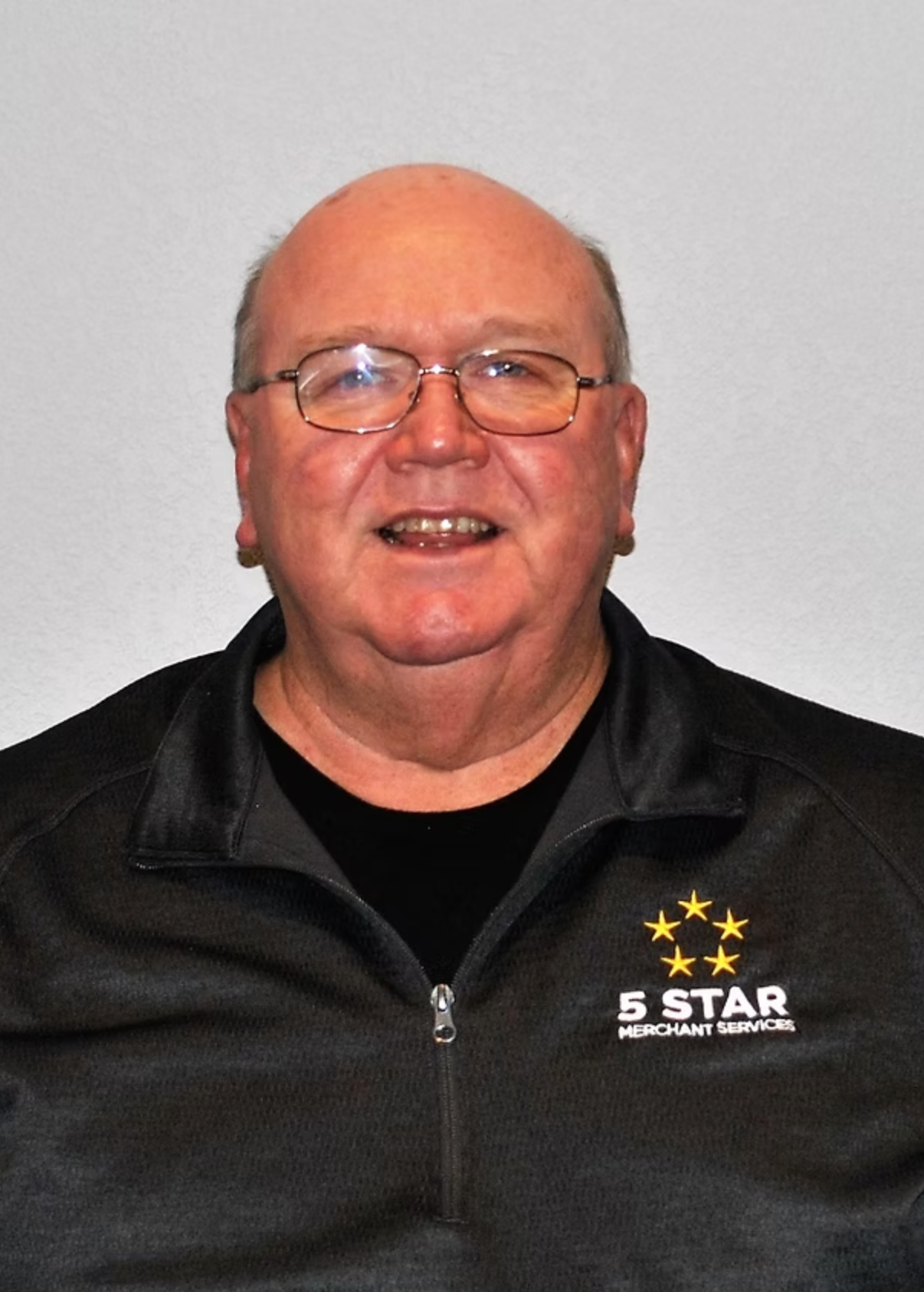 A man wearing glasses and a black jacket that says 5 star