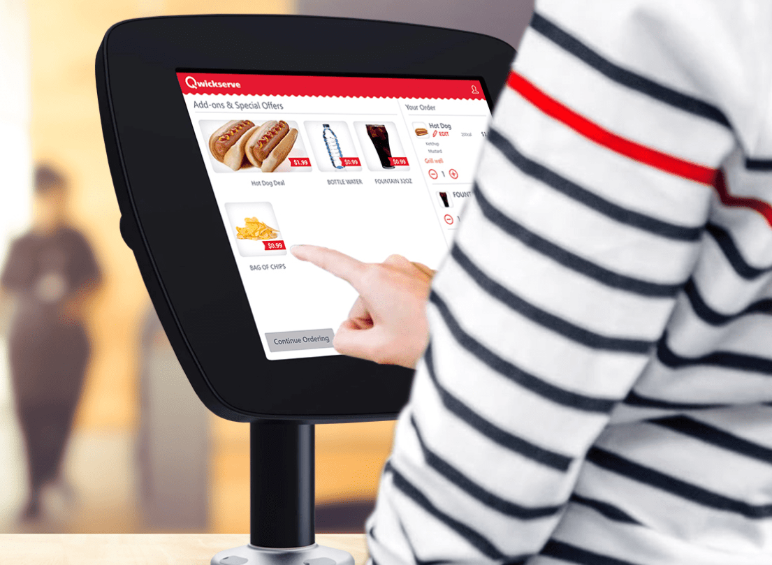 A person is using a touchscreen to order food at a restaurant.
