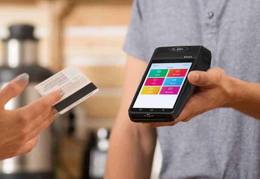 A person is holding a credit card and a cell phone.