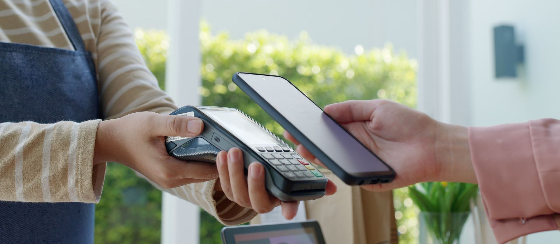 A person is paying with a cell phone in a store.