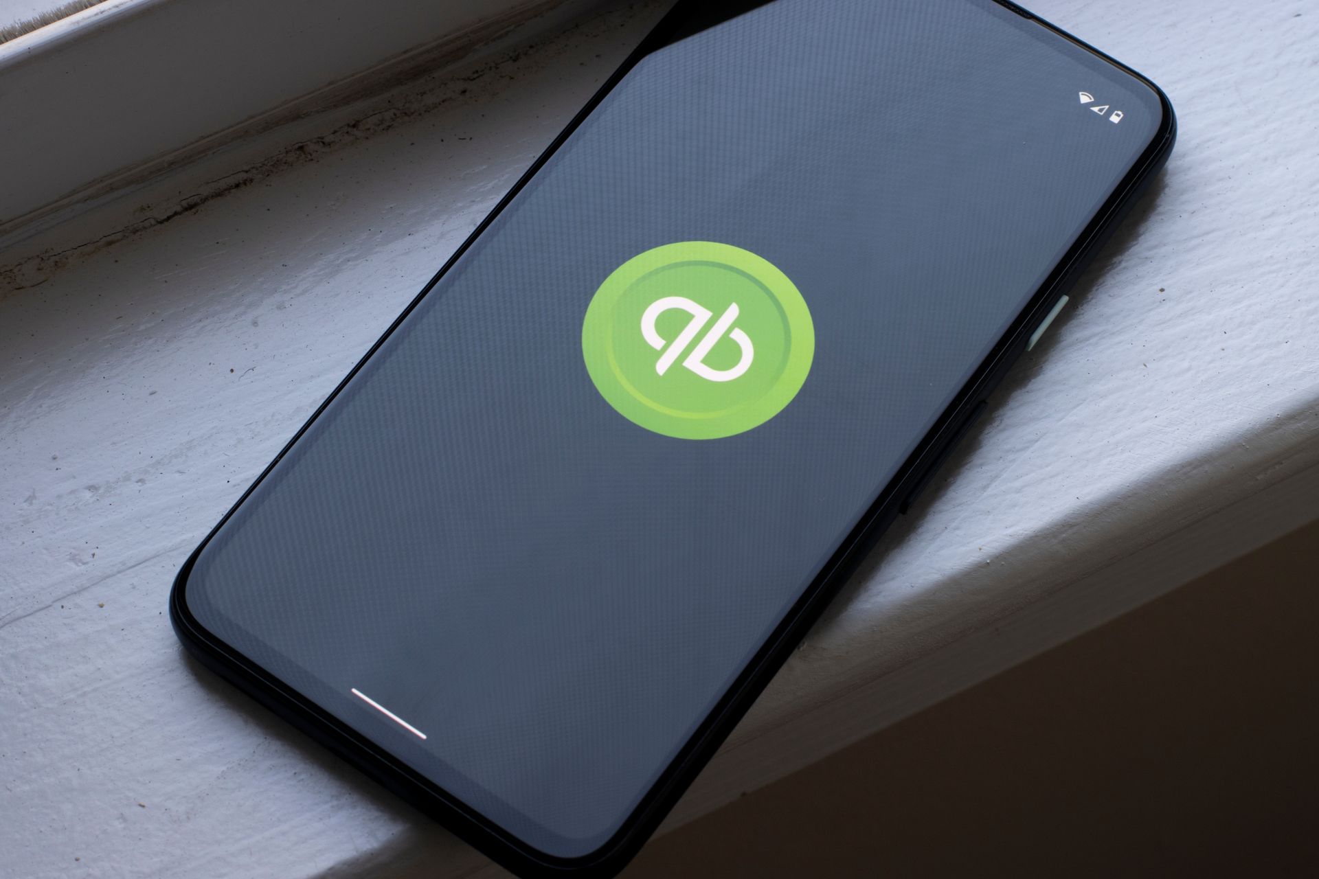 A cell phone with the qb logo on the screen