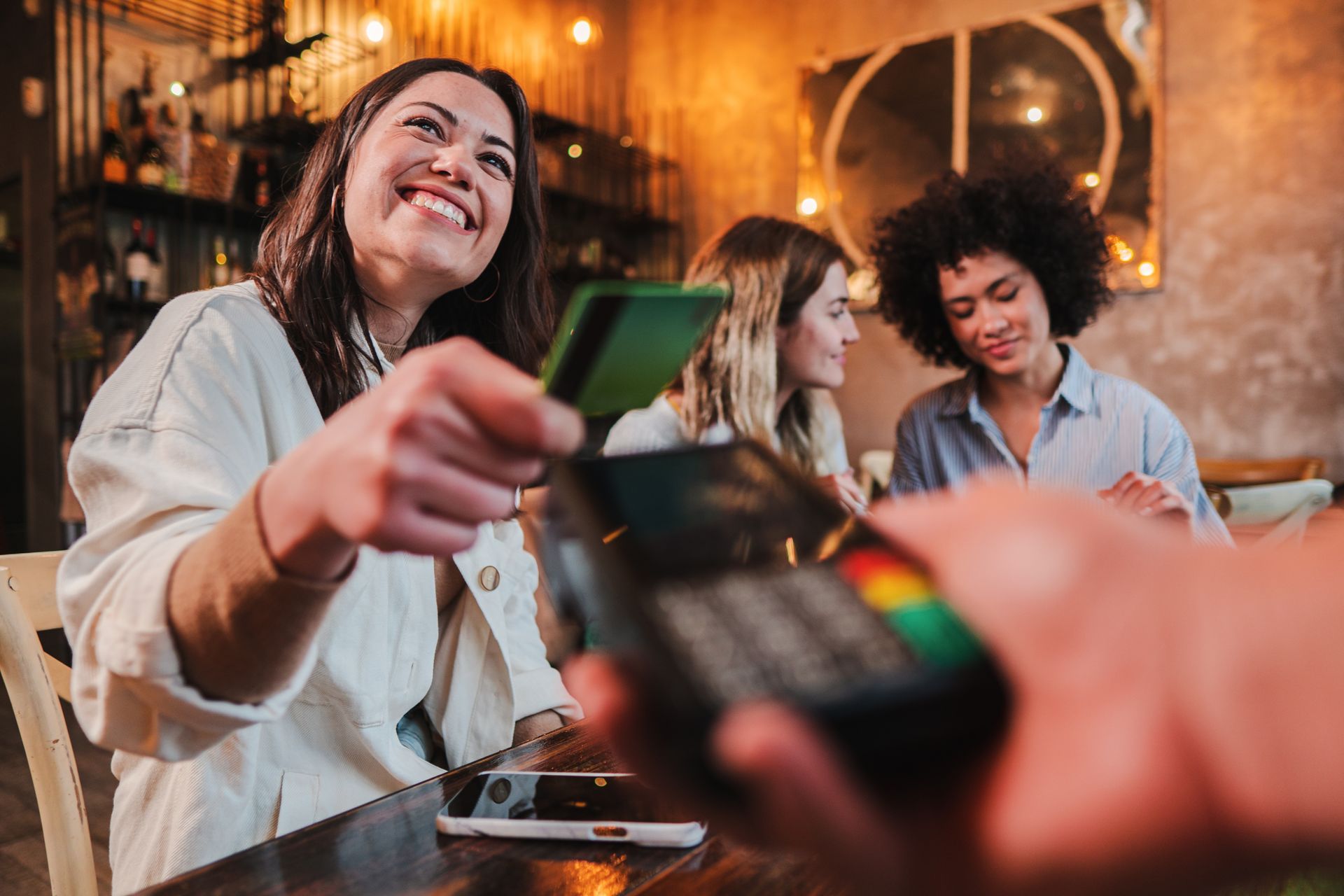 A woman is paying with a credit card in a restaurant.