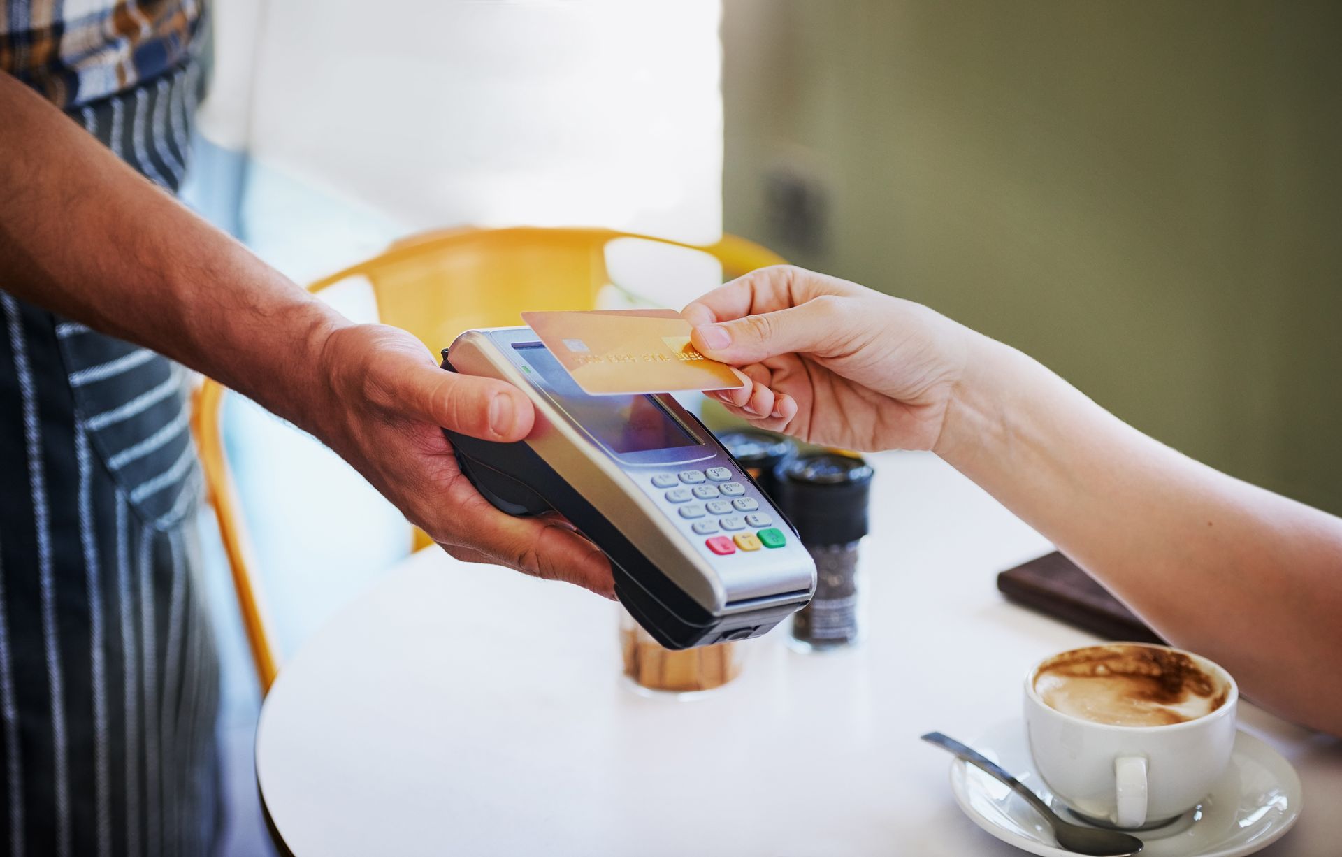 A woman is paying for a cup of coffee with a credit card.