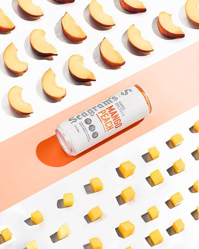 Food and beverage photography of Seagram's Mango Peach Hard Seltzer with peach slices and mango cubes. Product photography by JAM Creative for Seagram's Hard Seltzer/FIFCO USA.
