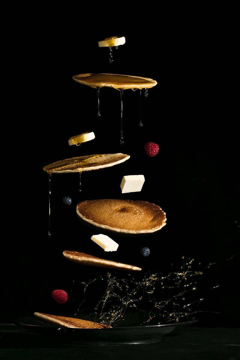 High-end food photography of pancakes, butter, maple syrup and berries flying through the air. Product photography for Runamok Maple by JAM Creative.