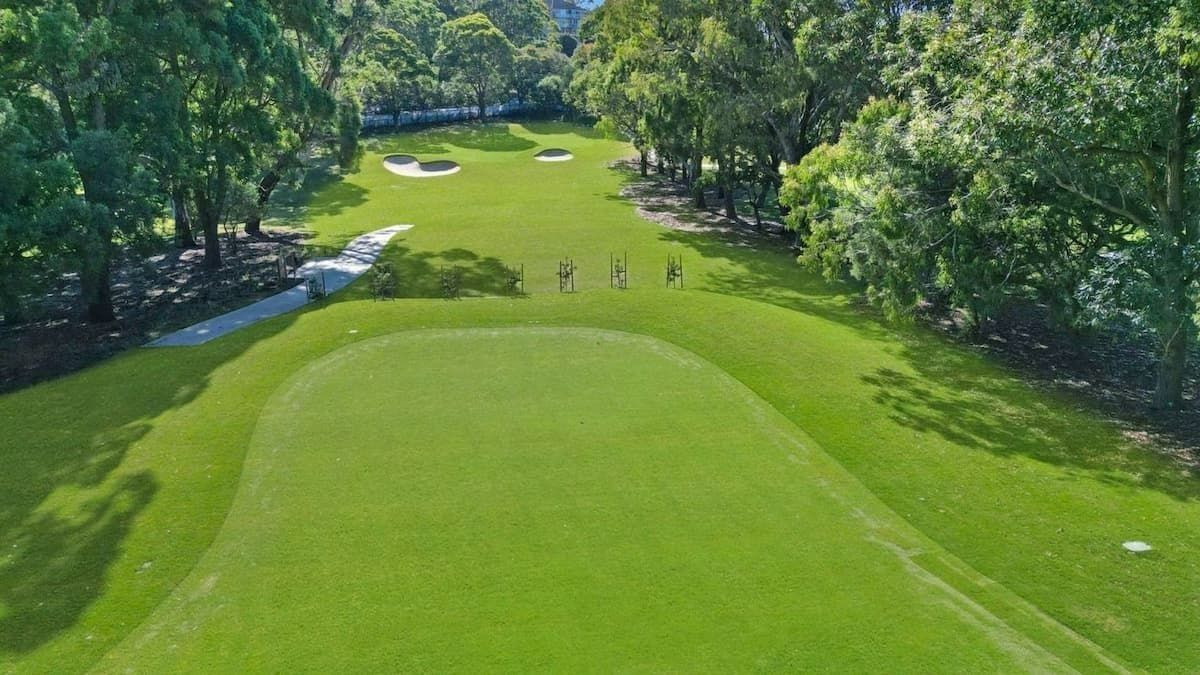 A Green Golf Course, with Trees Lining the Fairway and Golfers Preparing to Hit — Top Notch Turf in Rasmussen, QLD