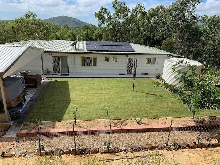 White House with Solar Panels, Carport, and Green Lawn — Top Notch Turf in Rasmussen, QLD