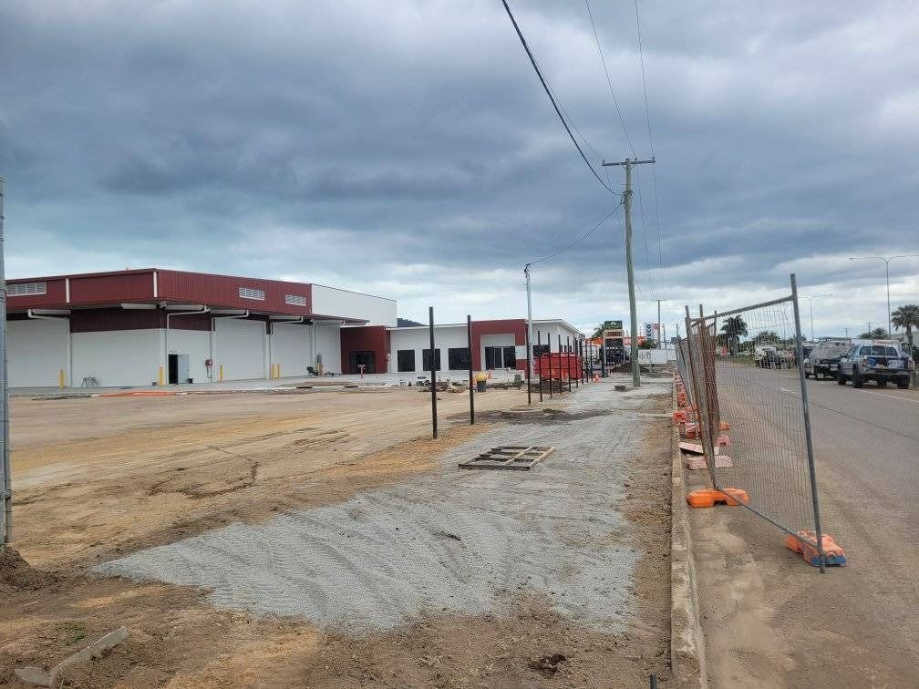 Construction Site with Sidewalk, Building in The Background, Cloudy Sky — Top Notch Turf in Rasmussen, QLD