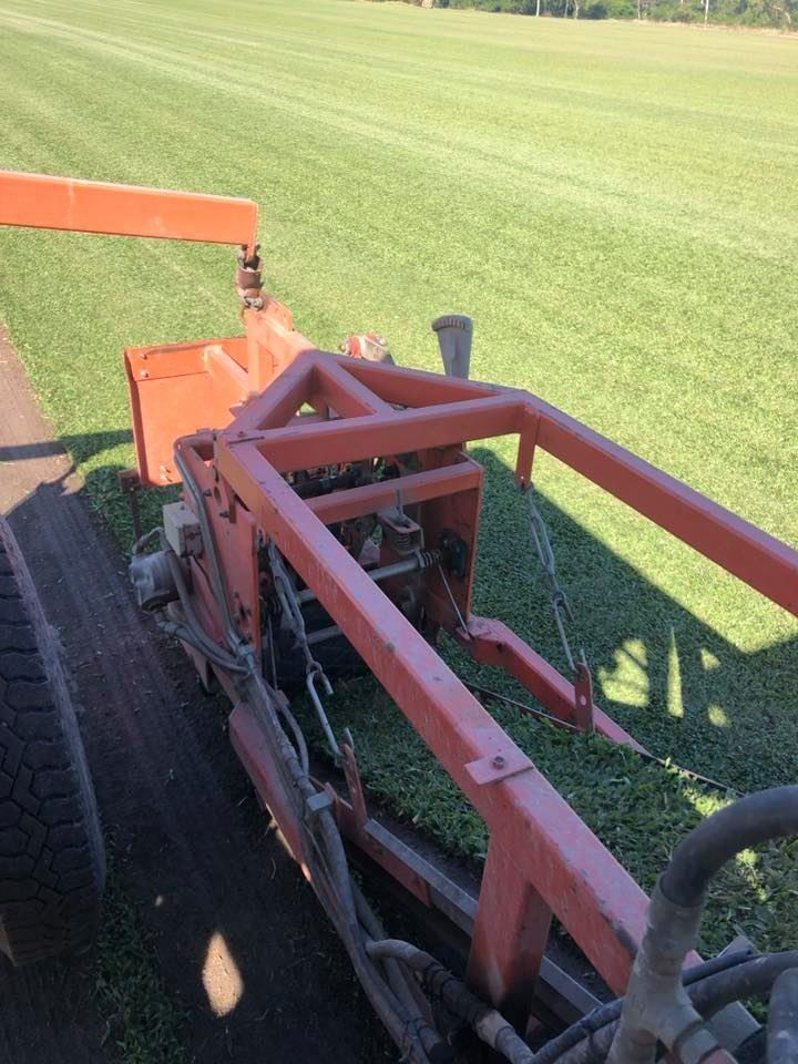 Orange Sod Cutter Machine on A Green Grassy Field — Top Notch Turf in Rasmussen, QLD