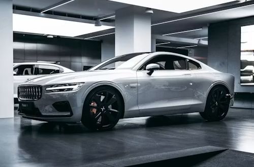 Silver luxury sports car parked in a modern indoor showroom, side view