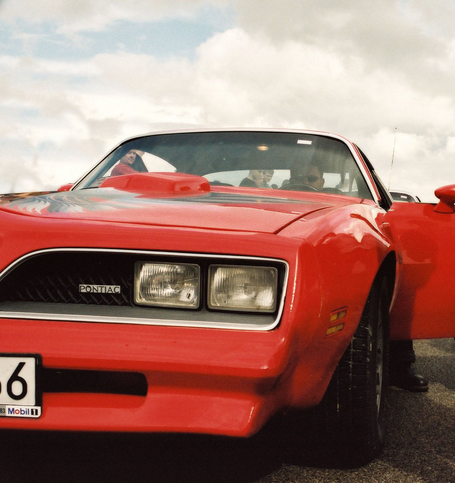 A red car with a license plate that says o on it