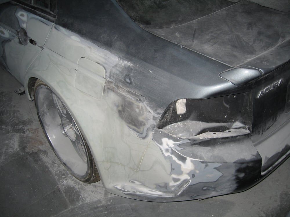 A car with a damaged bumper is sitting on the ground.