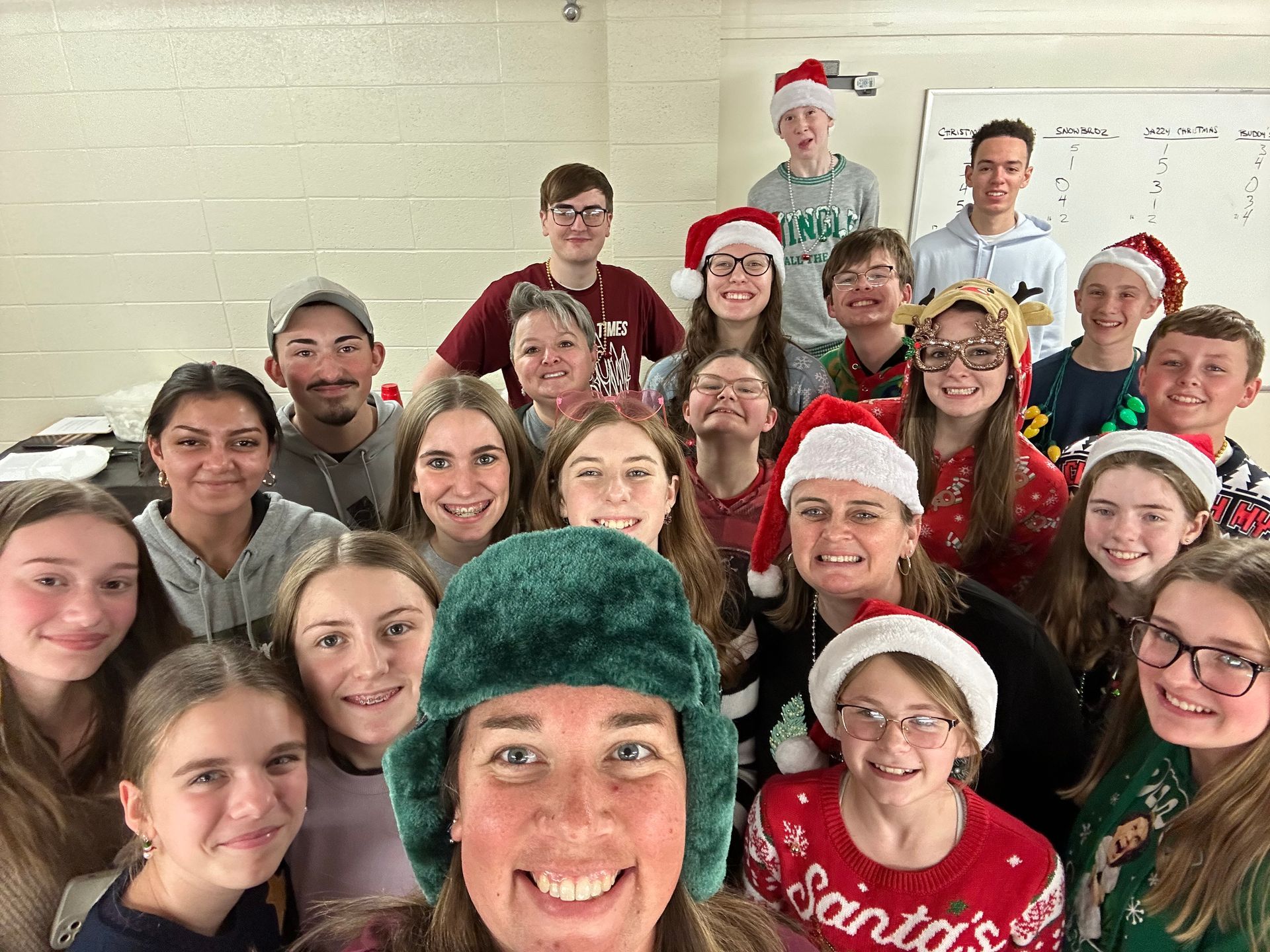 Group of people in Santa hats posing for a festive holiday photo indoors