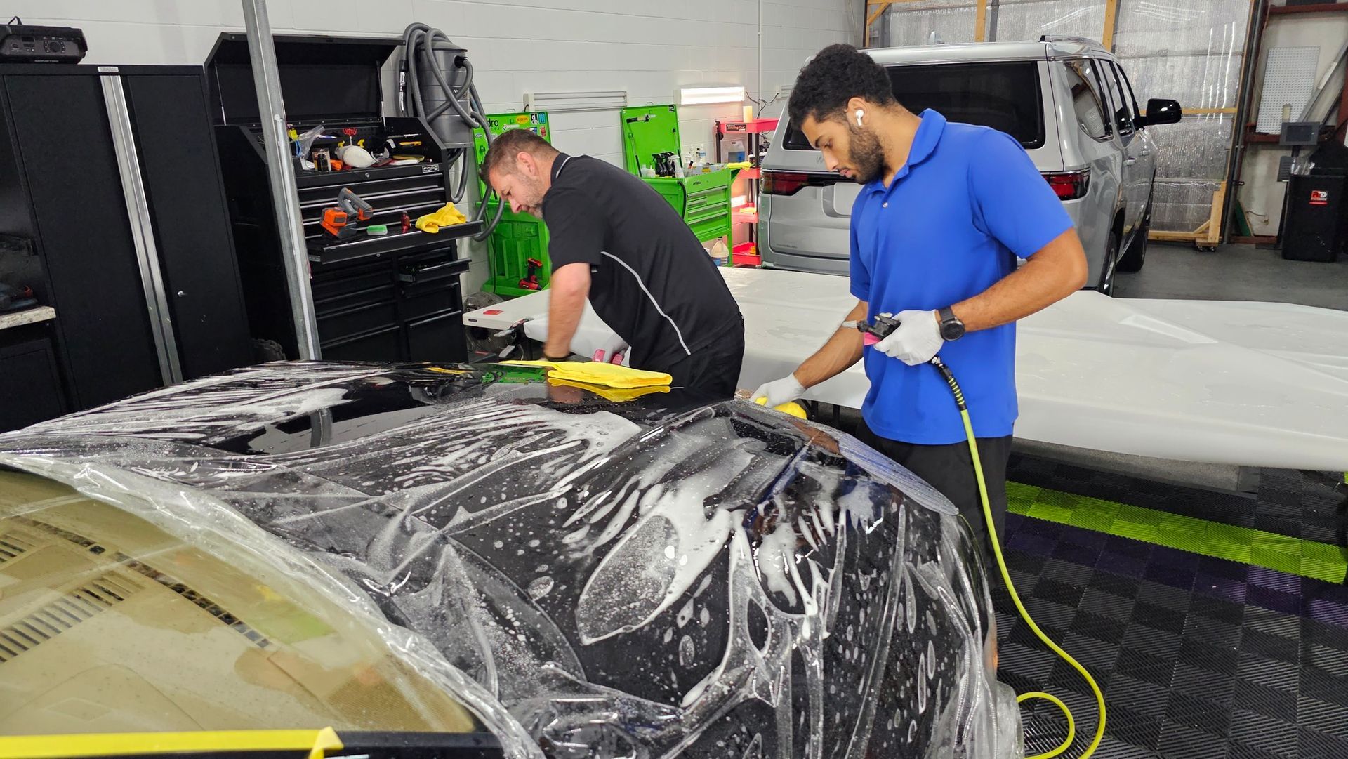 Installing paint protection film (PPF) on a car hood at CarZmedics.