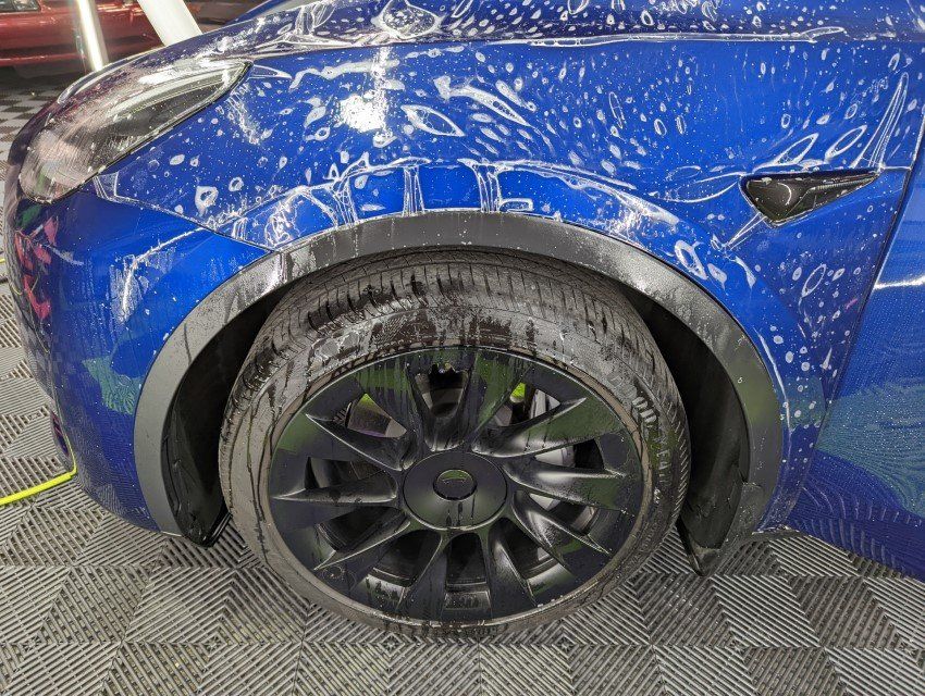 Tesla receiving paint protection film (PPF) installation on the fender