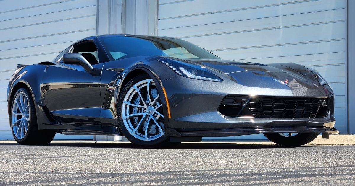 Corvette with a mirror-like ceramic coating reflecting sunlight, showcasing a professional service.