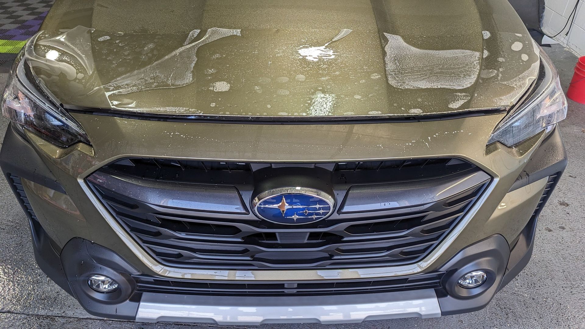 Subaru receiving paint protection film (PPF) installation on the hood.