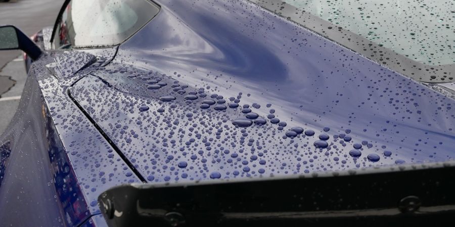 A ceramic coating for car with water beading on it due to hydrophobic properties.