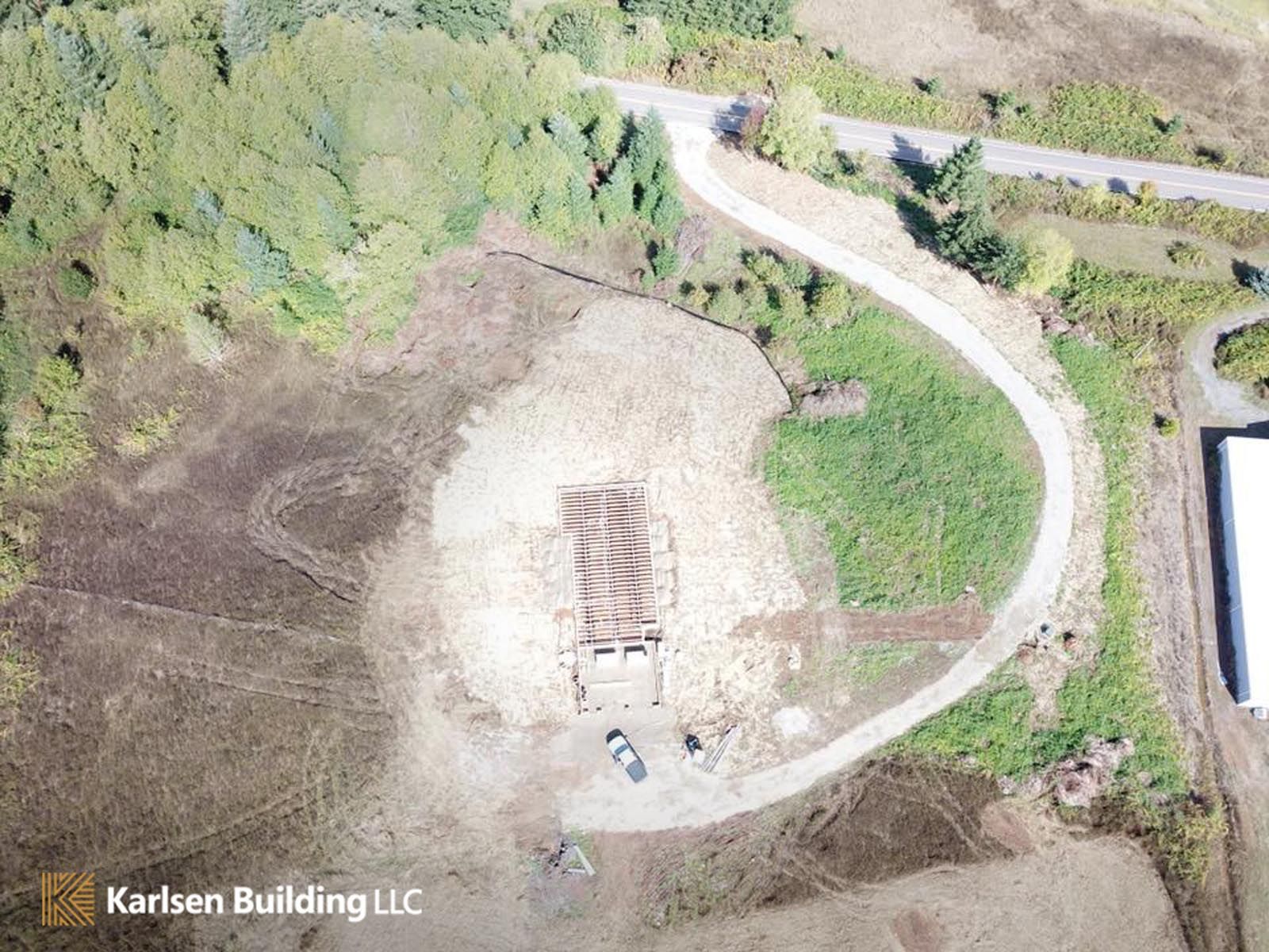 An aerial view of a dirt road going through a field.