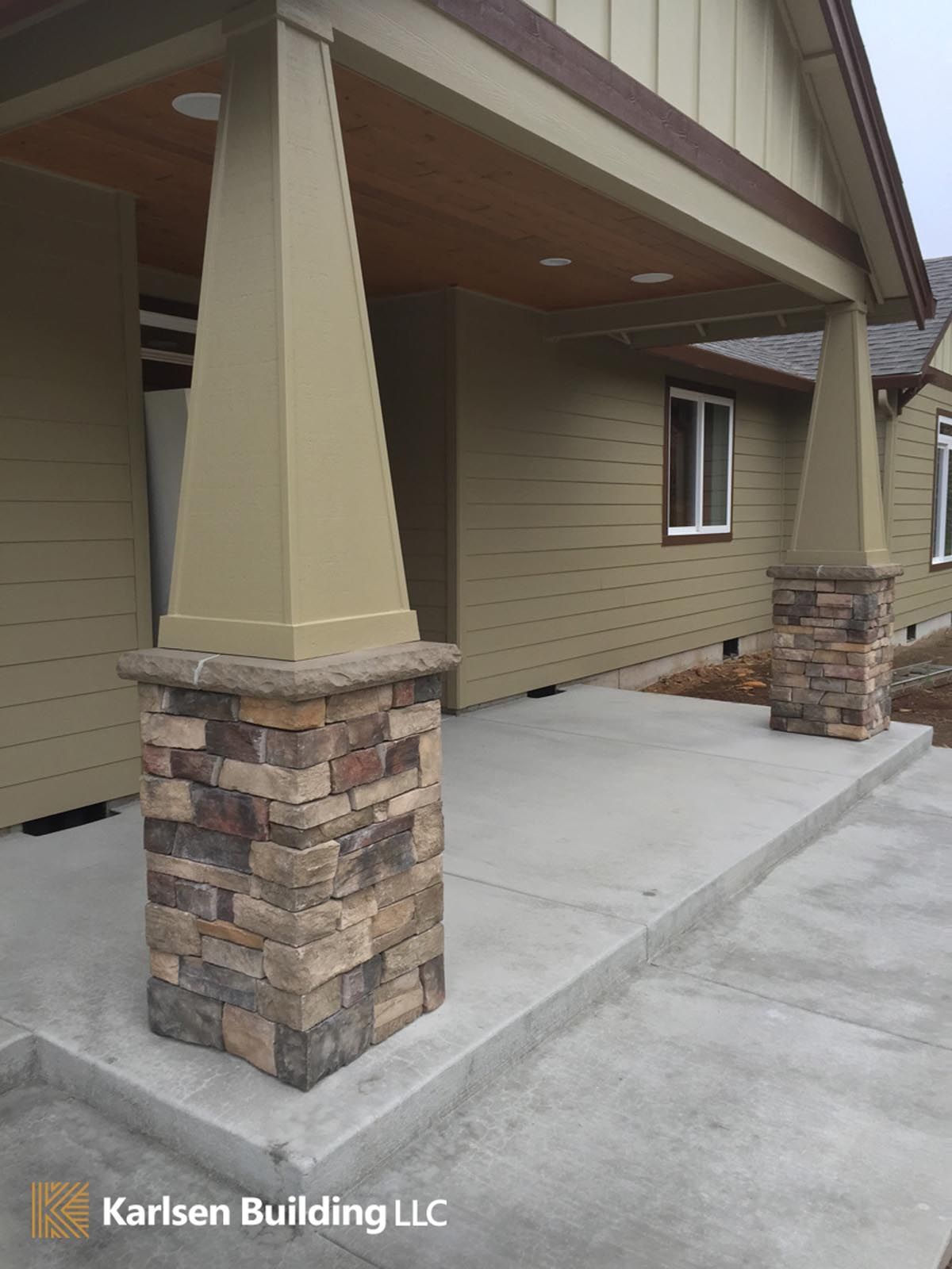 A house with a porch and pillars on the side of it.