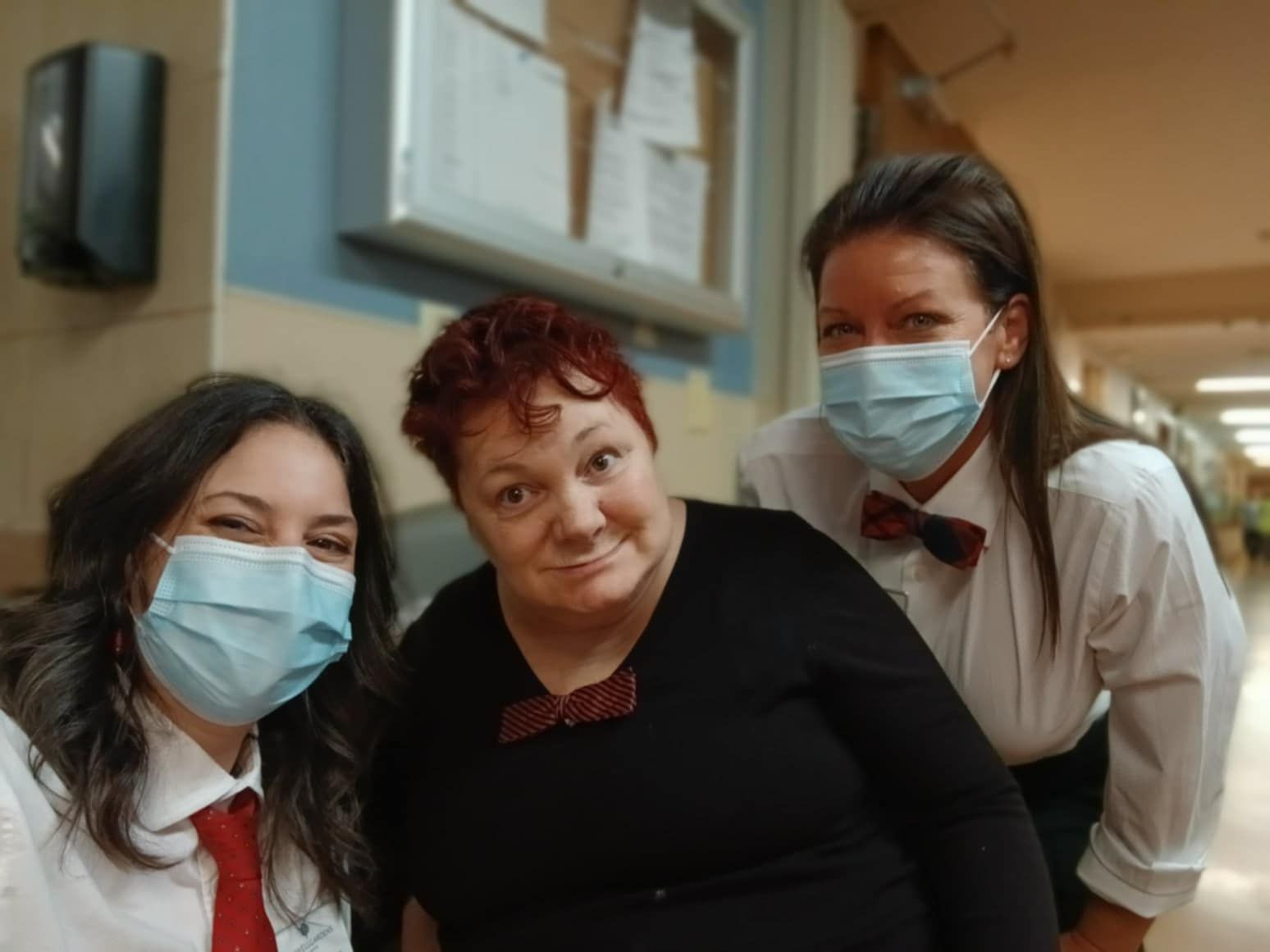 Three women wearing face masks are posing for a picture