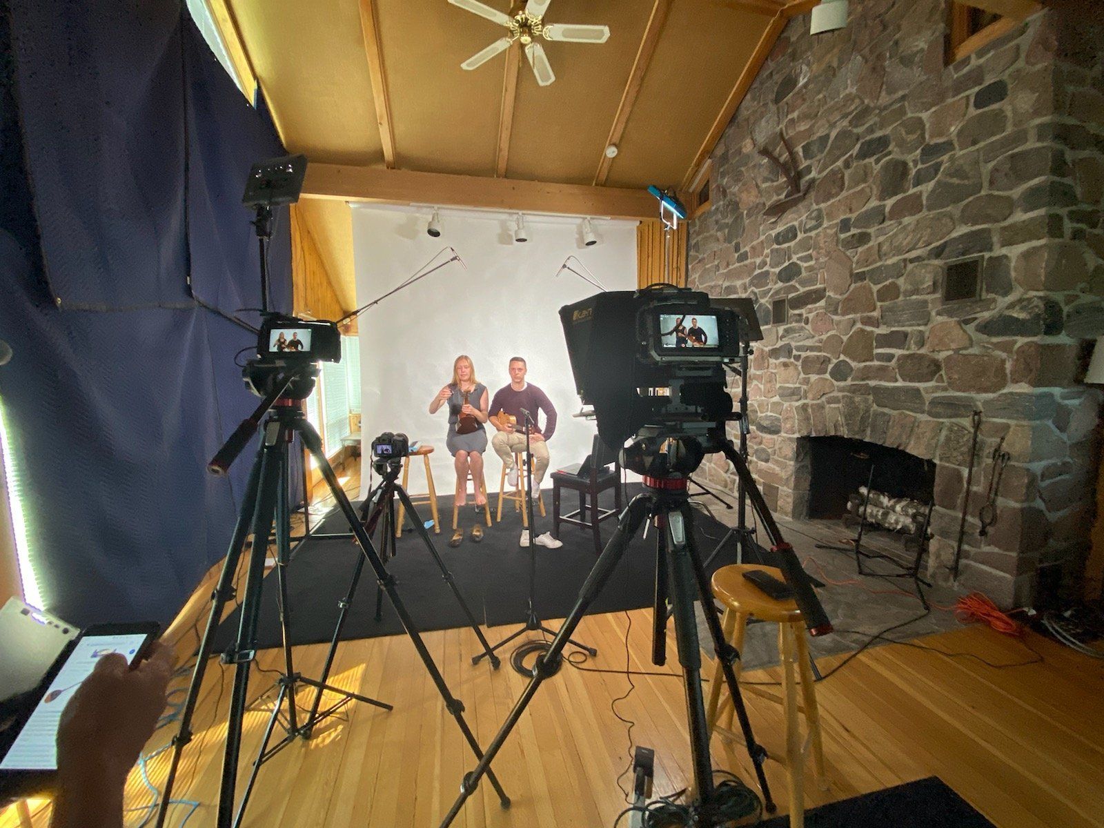 A man and woman are standing in front of a camera in a room.