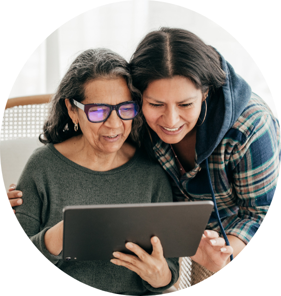 Two women are looking at a tablet together.
