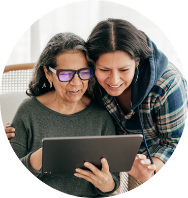 Two women are looking at a tablet together.