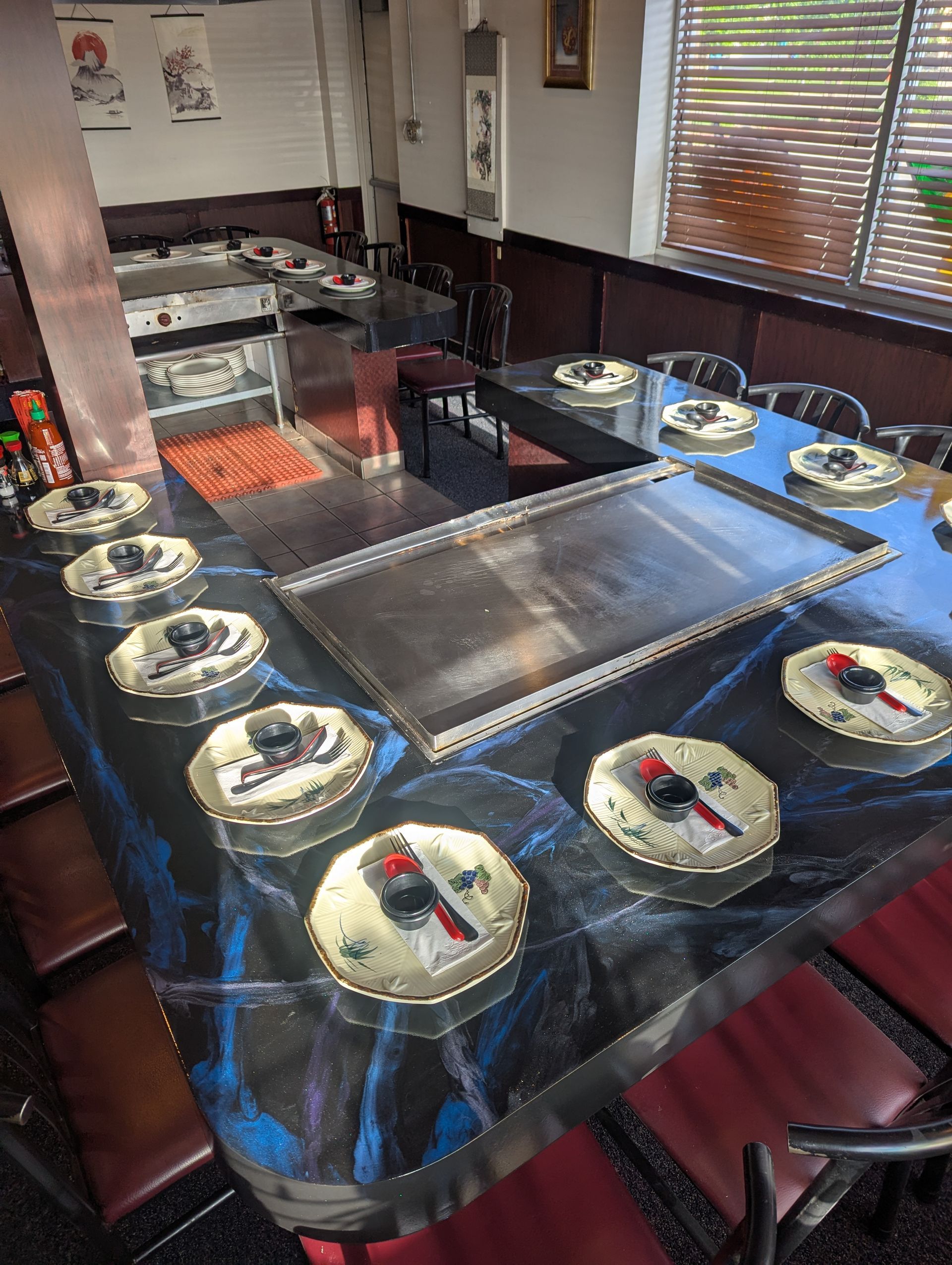 Sushi conveyor belt dining table with plates of food around a grill in a restaurant
