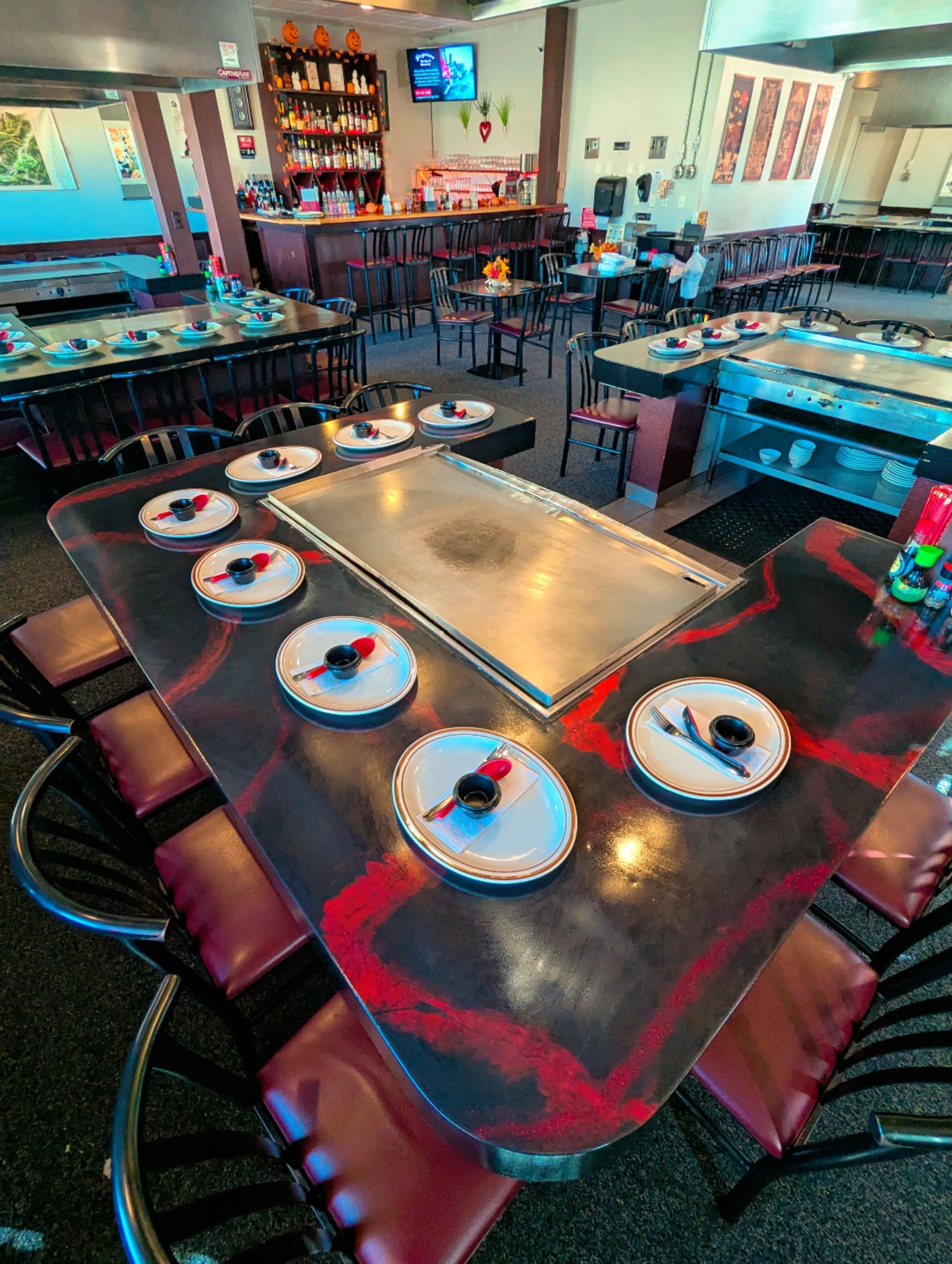 Restaurant dining table set with plates and glasses, viewed from above in a colorful dining room