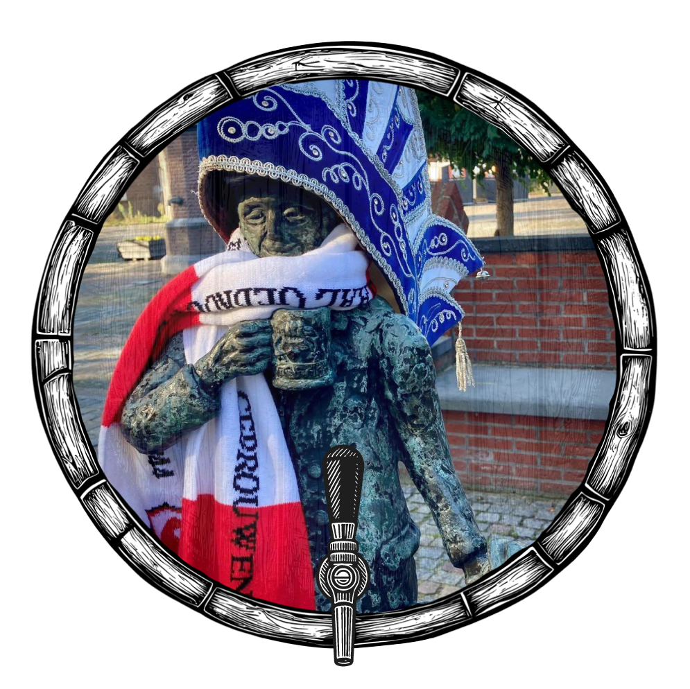 Beeld van een man met een sjaal en een hoed, omlijst door een vat met een kraan aan de onderkant.