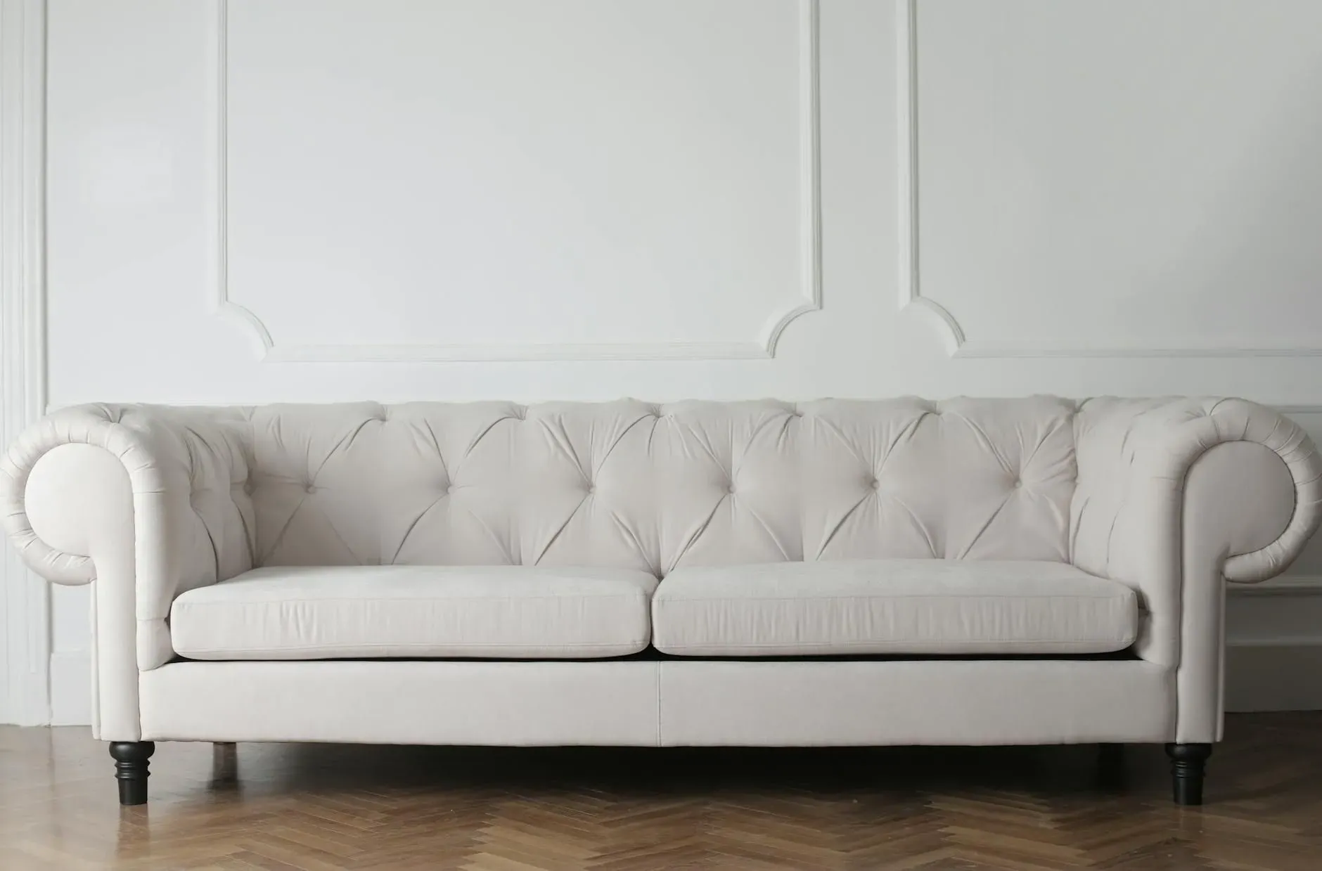 White tufted sofa against a paneled wall in a minimalist room