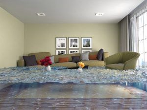 Modern living room with sofa, armchair, framed wall art, and a bed in the foreground by a bright window