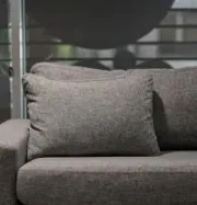 Gray sofa with textured pillows in front of a window with blinds