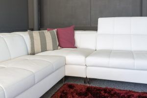 White sectional sofa with striped and pink pillows in a modern living room