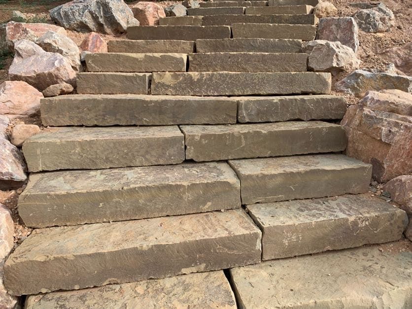 Stone staircase on a rocky hillside, viewed from below.