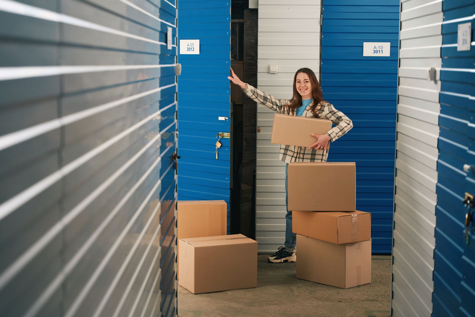 Woman storing cardboard boxes in a self-storage unit