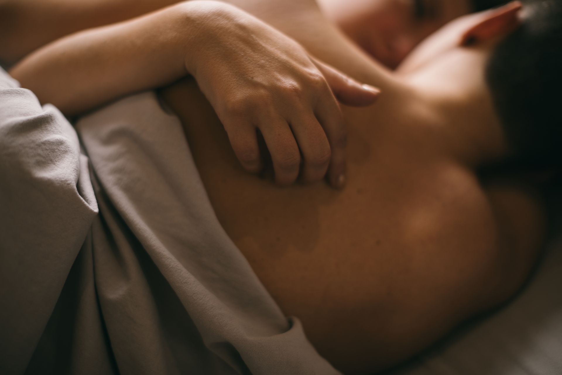 gay couple cuddling in bed. hand on the partner's back. love and passion. Tenderness in bed. Sexual relationships