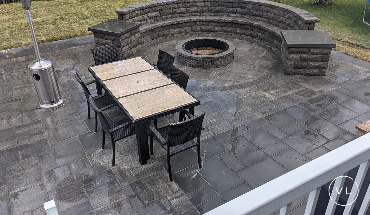 Outdoor patio with a fire pit, seating area, dining table, and a patio heater.