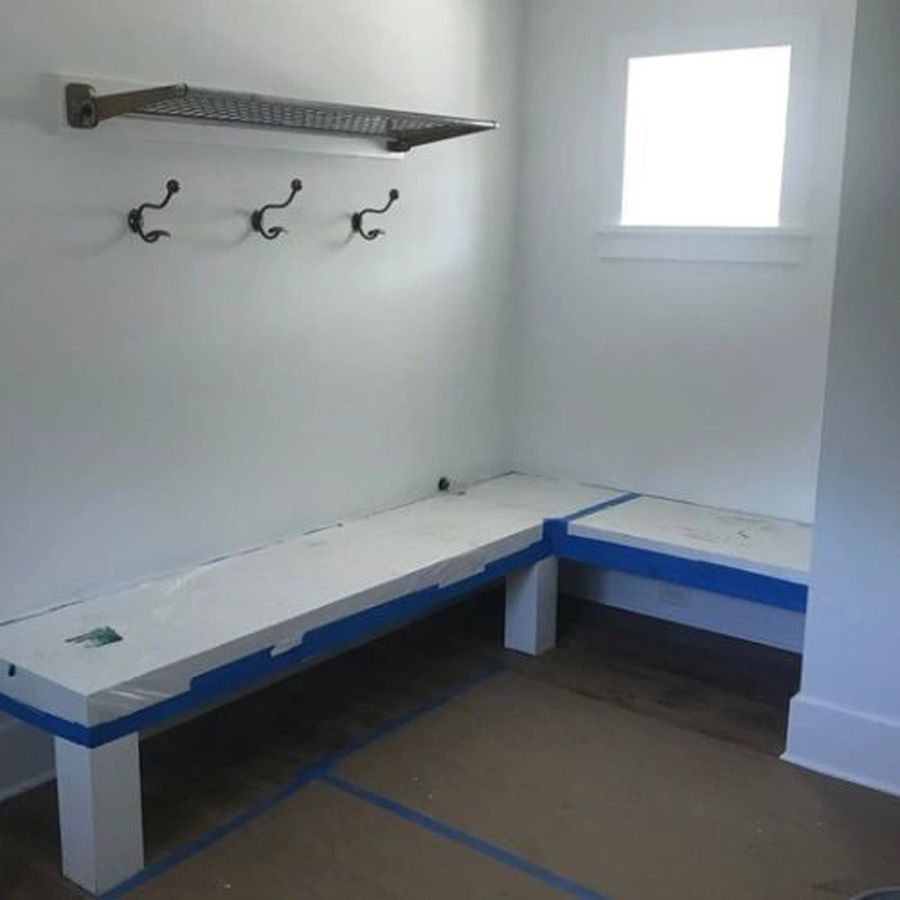 A room with a bench and hooks on the wall