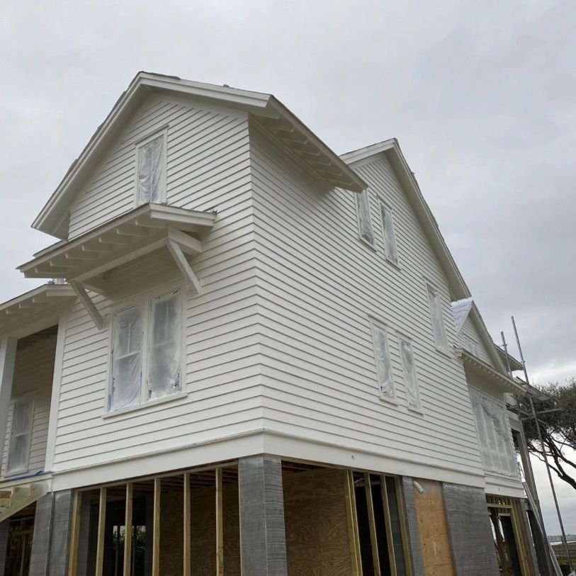 A white house is being built on a cloudy day.