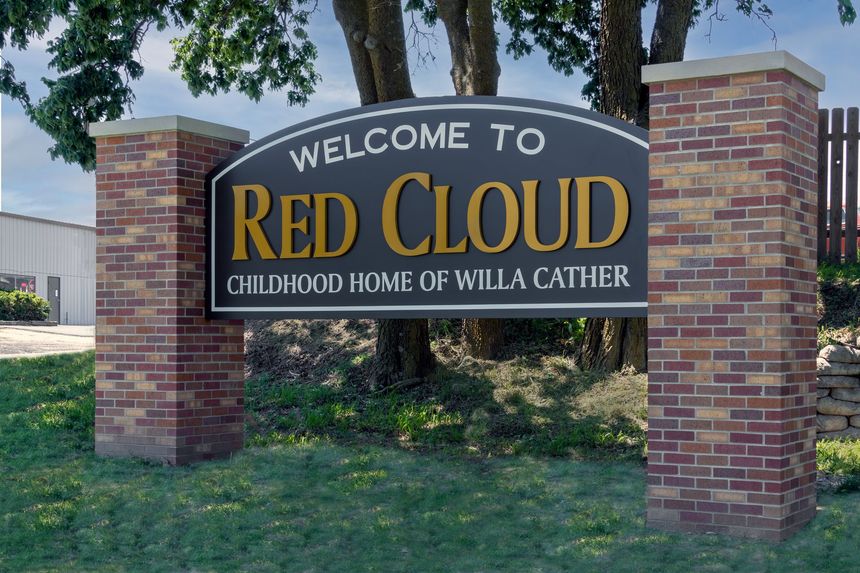 Welcome sign for Red Cloud with brick pillars,